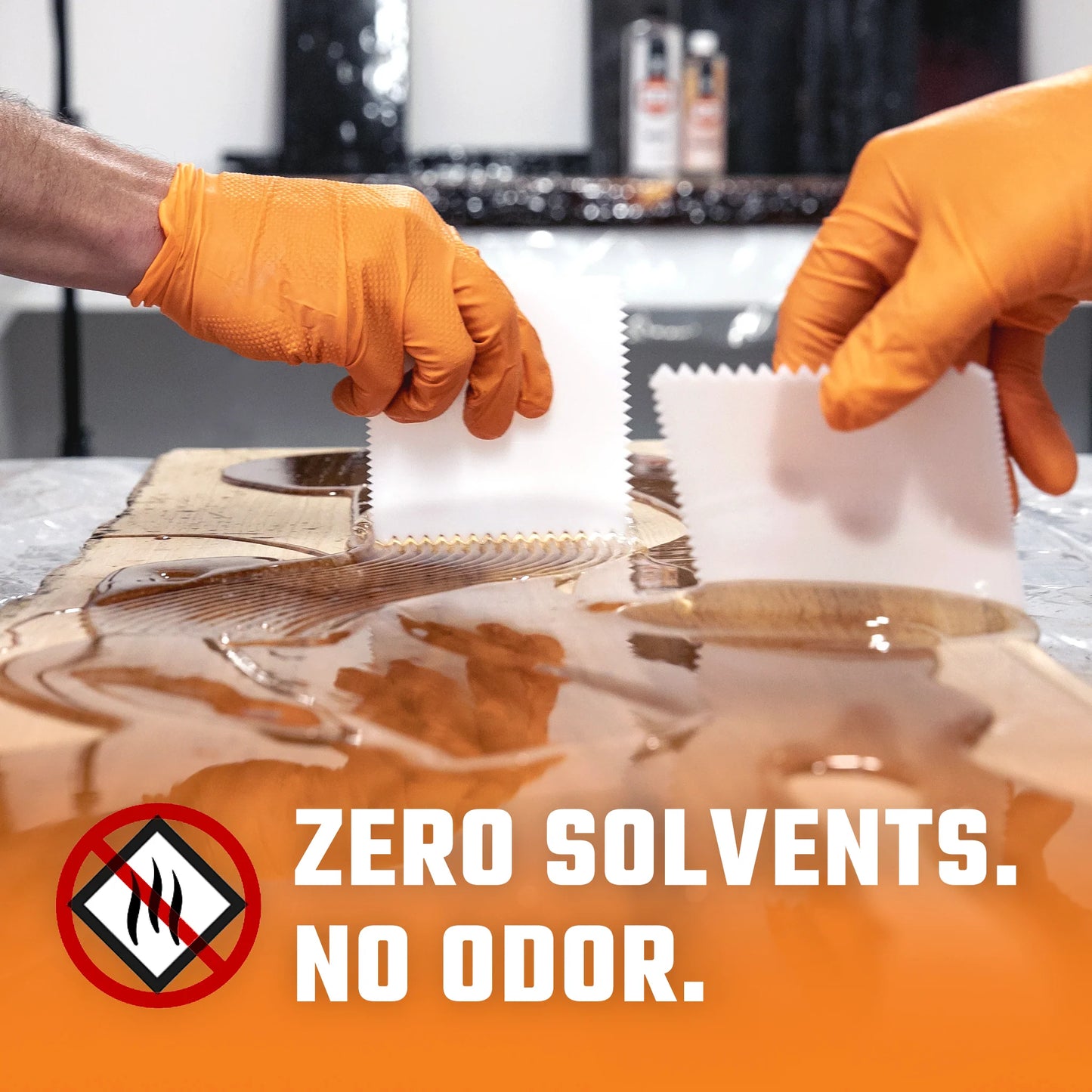 Hands with a scrapers spreading rock-hard epoxy resin from Industrial Clear.